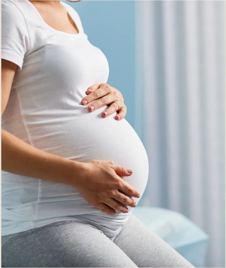 A pregnant woman sitting on an examination table